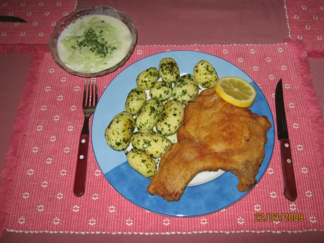 Schweinskotelett gebacken mit Petersilerdäpfeln & Rahm Gurkensalat